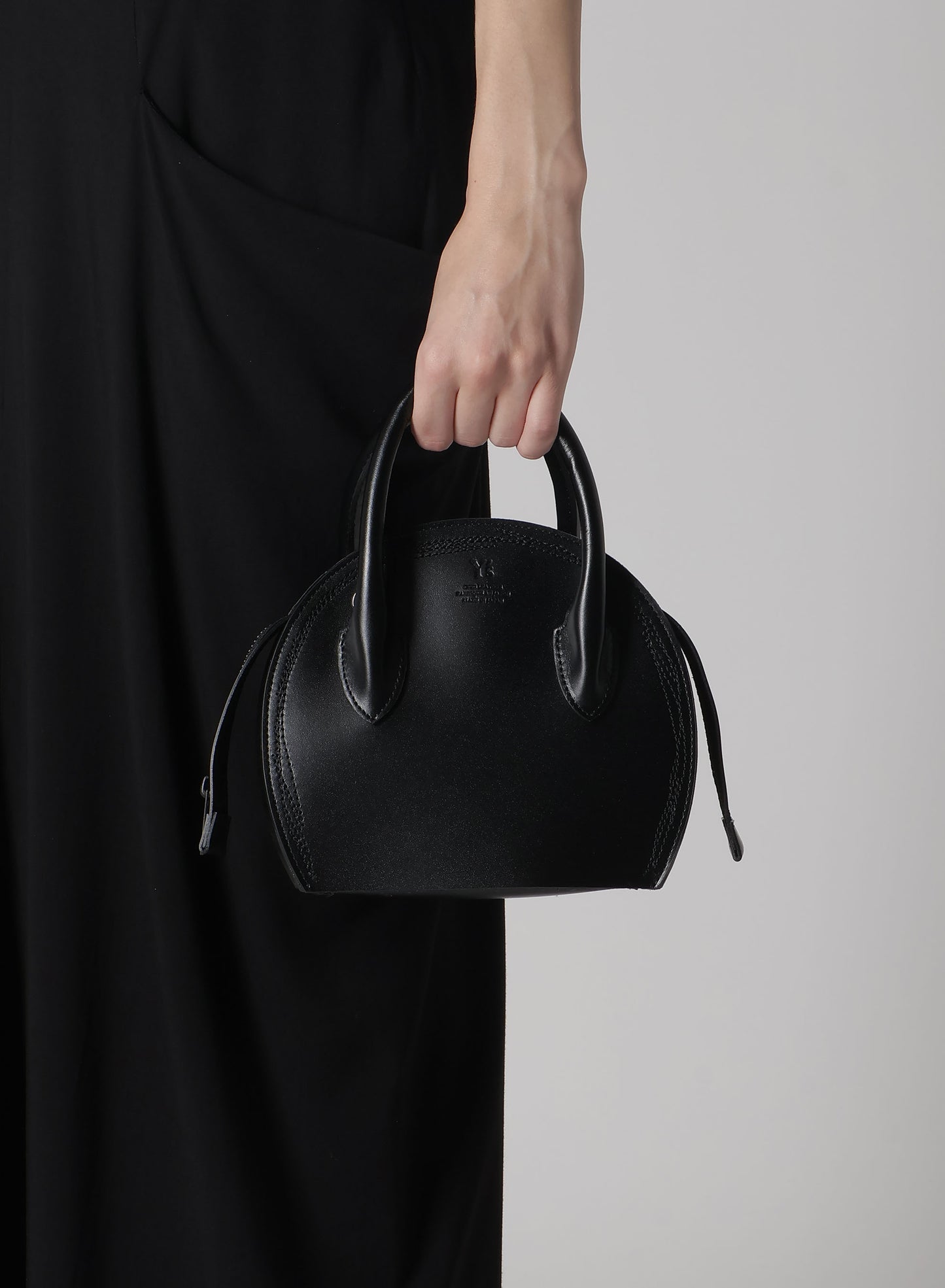 SEMI-GLOSS LEATHER CHOPPED ROUND BAG